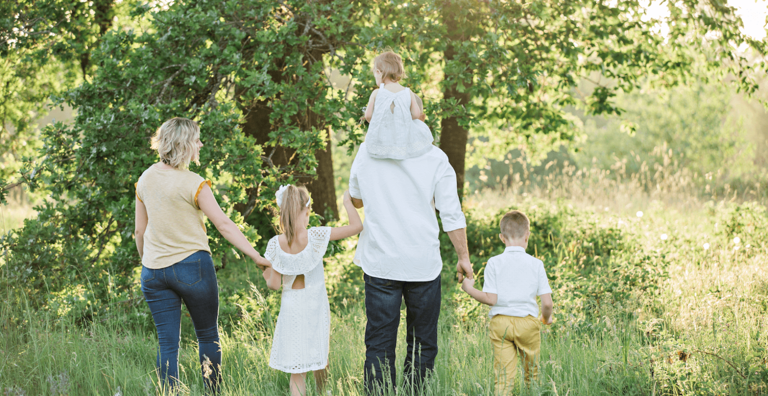 happy family walking through field - The Jackson Law Group
